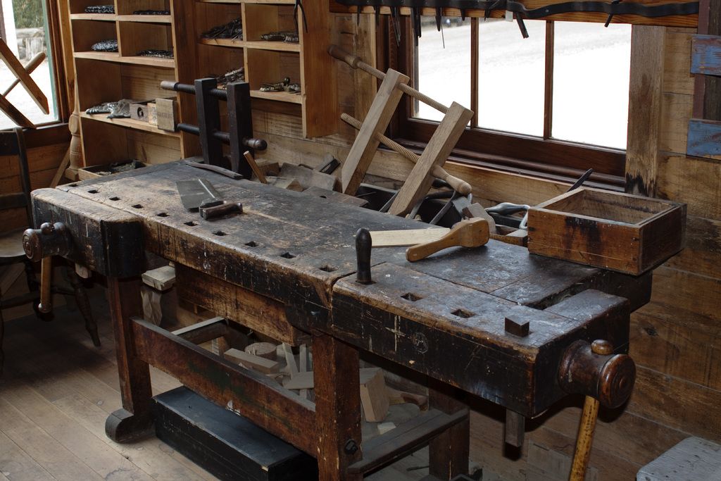A classic wooden workbench with clamps, planes and hand tools